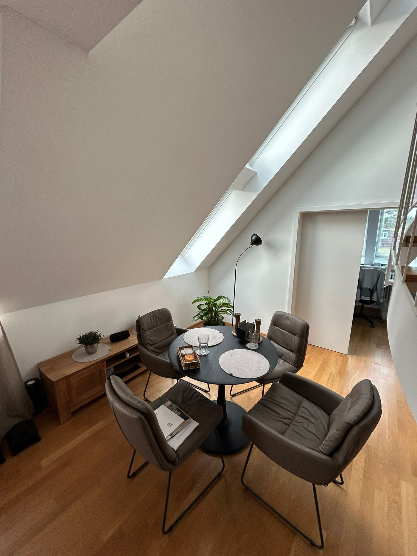 Dining area on the gallery level with a round table and leather chairs