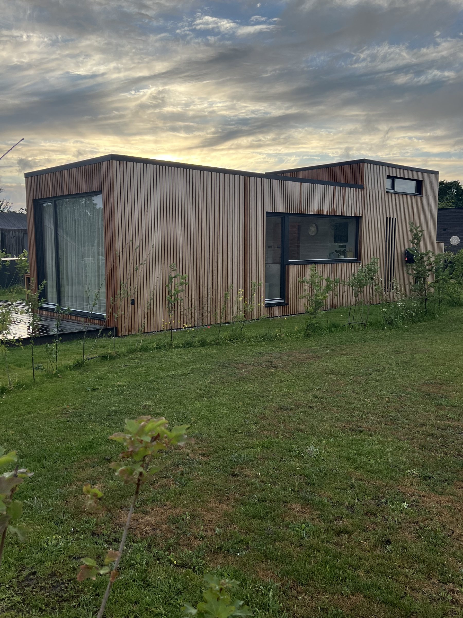 Timber facade of the tiny house on the kitchen side, with the long kitchen window