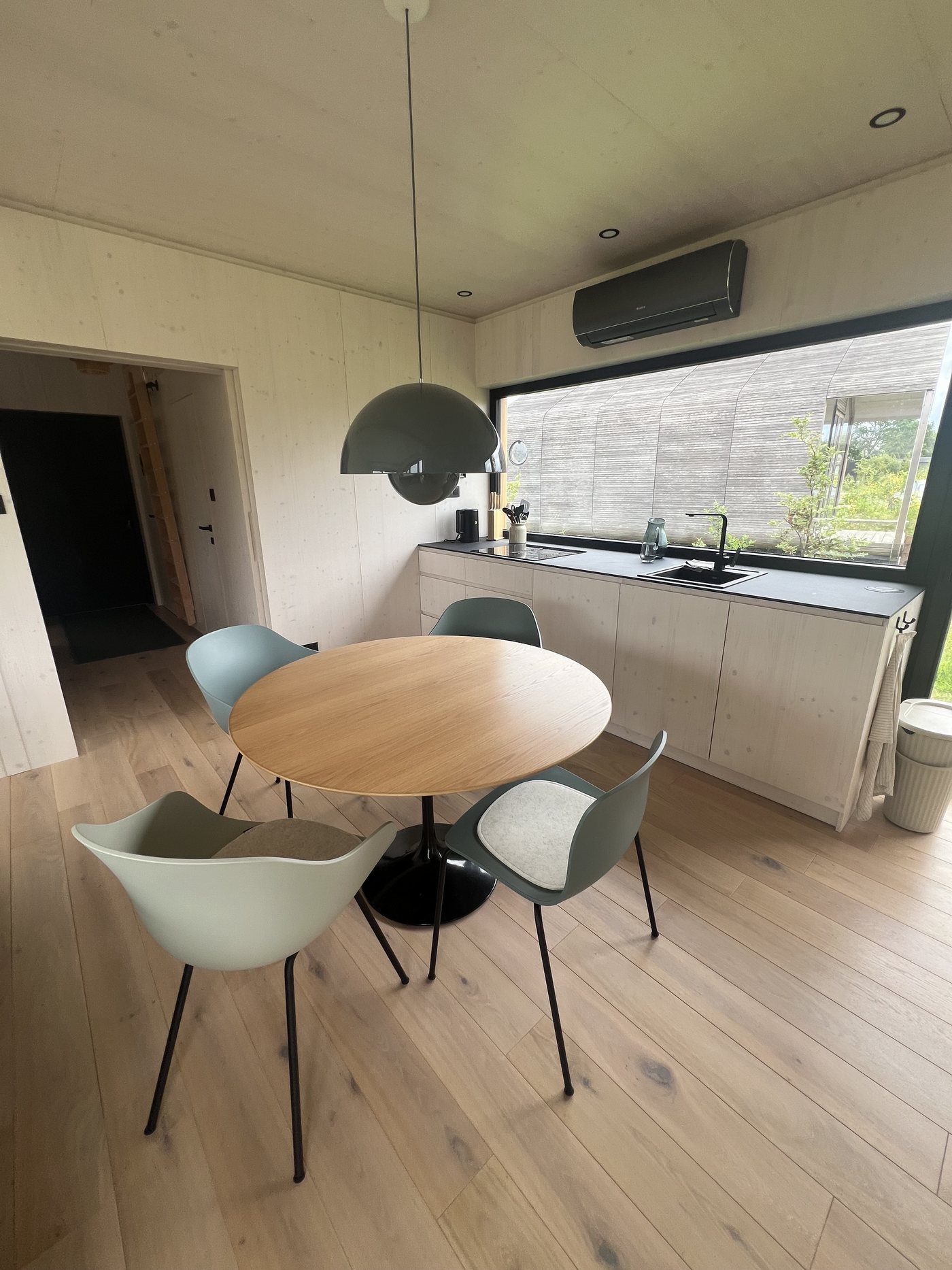 Dining area with shell chairs in sage green and black