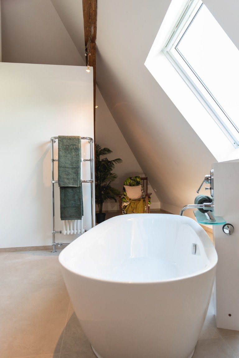 Freestanding bathtub beneath the roof window