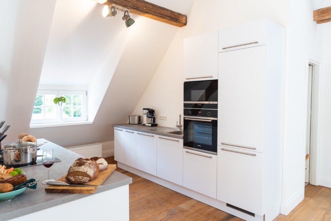White fitted kitchen beneath the sloping ceiling
