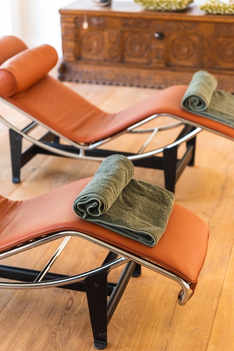 Lounger in cognac leather with sage-green towels