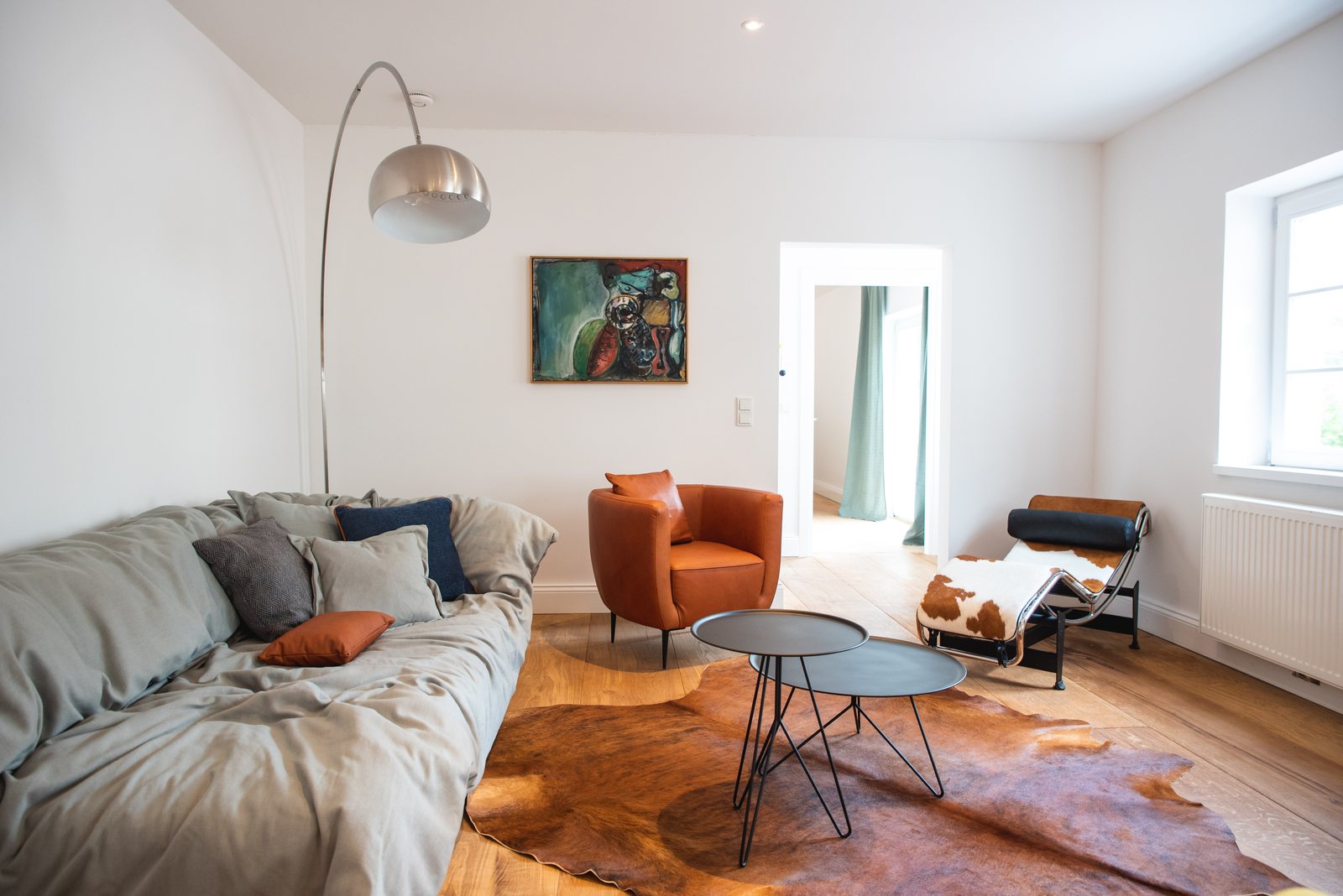 Living room with sofa, cowhide and orange armchair